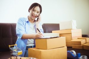 A lady on a call surrounded with boxes 