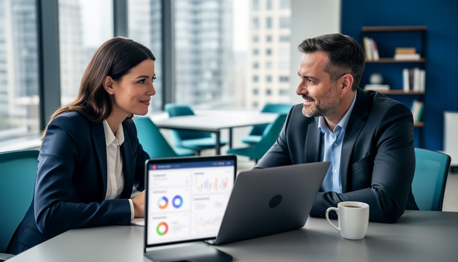A marketing consultant and a Canadian SMB founder collaborating in an office while reviewing a laptop with non-readable analytics for B2B growth strategy.